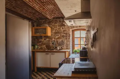 a kitchen with a table and a brick wall at La Bushaye in Aubel