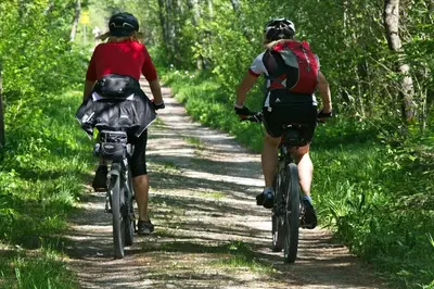 two people riding bikes down a dirt trail at Chalet Bosrust met serre & privéparking Natuur nabij Maastricht in Lanaken