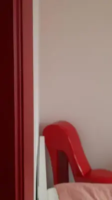 a red chair sitting next to a bed at Chambre d'hôte, la rouge in Liège