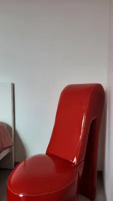 a red chair sitting in a corner of a room at Chambre d'hôte, la rouge in Liège