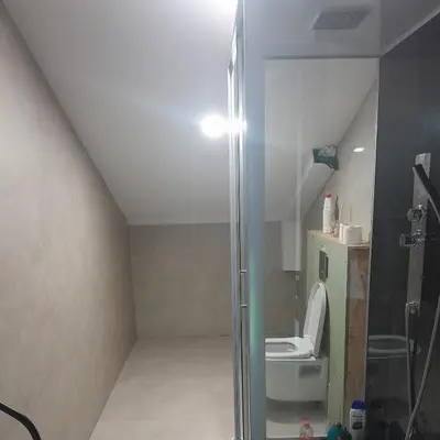 a bathroom with a toilet and a glass shower stall at RELAX Room in Chaudfontaine