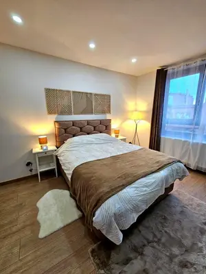 a bedroom with a large bed and a large window at Jolie petite maison in Liège