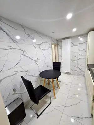 a table and chairs in a room with marble walls at Jolie petite maison in Liège