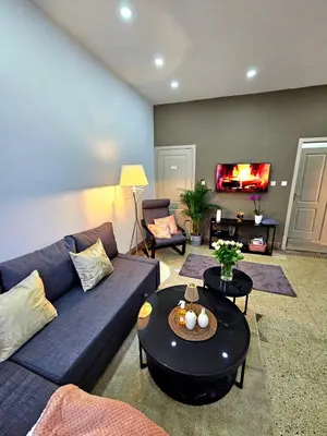 a living room with a blue couch and a table at Jolie petite maison in Liège
