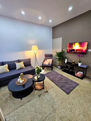 a living room with a blue couch and a fireplace at Jolie petite maison in Liège