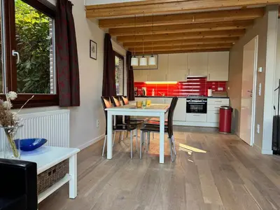 a kitchen with a table and chairs in a room at Forest lakehouse with Breathtaking Sauna in Lanaken
