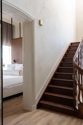 a staircase leading to a bedroom with a bed at Pastorij Huys in Heers