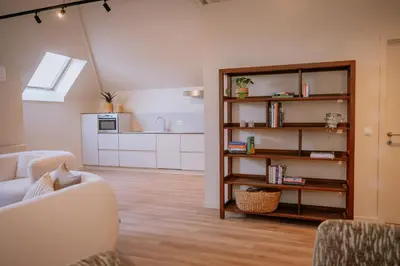 a living room with a couch and a kitchen at Pastorij Huys in Heers