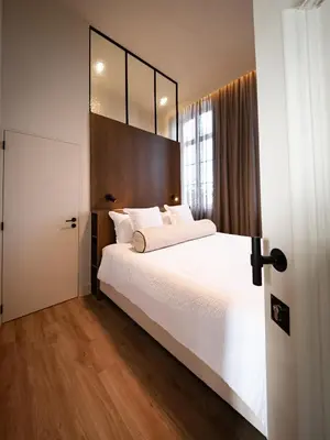 a bedroom with a white bed and a large mirror at Pastorij Huys in Heers