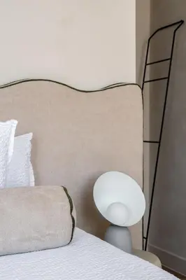 a bed with a chair and a lamp next to it at Pastorij Huys in Heers