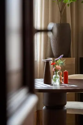 a table with a vase and flowers on it at Pastorij Huys in Heers