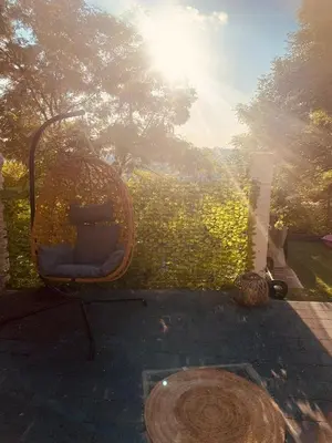 a wicker chair sitting in front of a wall at Quiet villa Exceptional view and its exterior in Liège