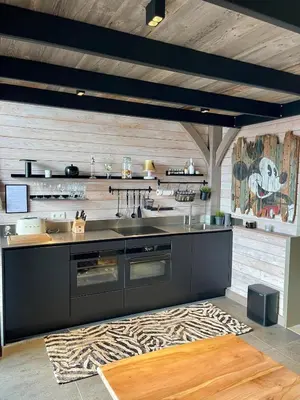 a kitchen with a black counter and a rug at La Perle du Fierain in Wegnez