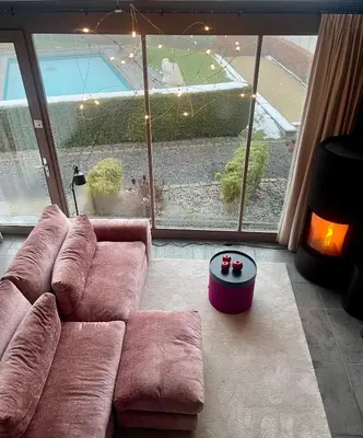 a living room with a couch and a large window at La Perle du Fierain in Wegnez