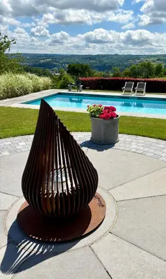 a large metal sculpture in front of a swimming pool at La Perle du Fierain in Wegnez