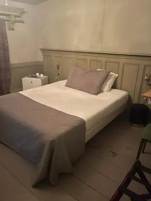 a bedroom with a large bed with white sheets at Sogni d oro in Peer