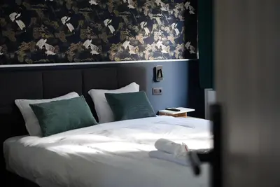 a bedroom with a white bed with green pillows at Min Su in Waremme