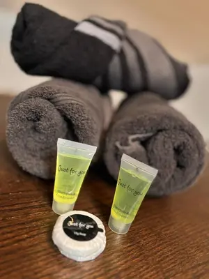 a teddy bear with two bottles of moisturizers on a table at Chambre spacieuse privée avec salle de bain privée in Liège