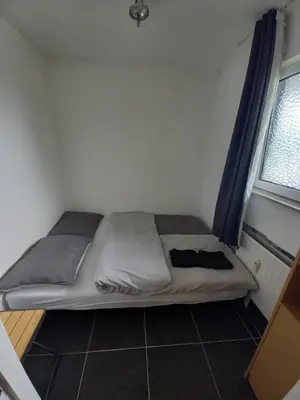 a bed in a small room with a window at Ap57 Nature Ardennes Economy class apartment in Kelmis