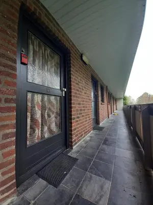 a brick building with a black door and a brick wall at Ap57 Nature Ardennes Economy class apartment in Kelmis