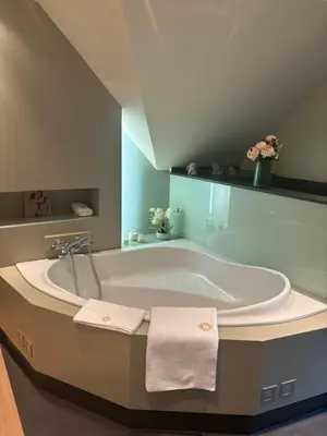 a bathroom with a large tub with towels on it at Sophia Rooms 14 in Maasmechelen