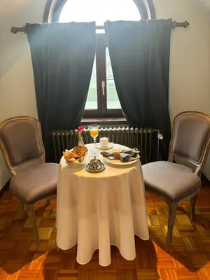 a table with a white table cloth and two chairs at Sophia Rooms 14 in Maasmechelen