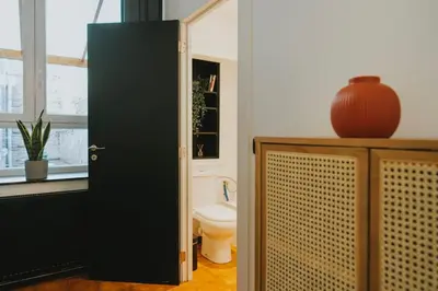 a bathroom with a toilet and a black door at 2 bedroom apartment near the city center in Liège