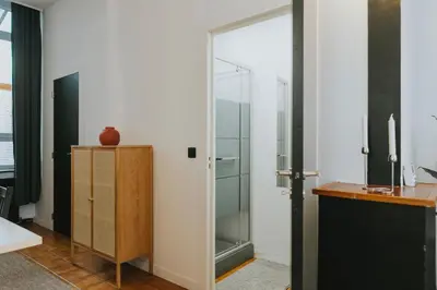 a bathroom with a glass shower door next to a desk at 2 bedroom apartment near the city center in Liège