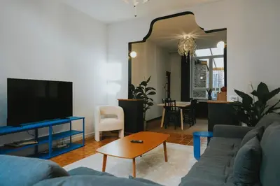 a living room with a couch and a tv and a table at 2 bedroom apartment near the city center in Liège