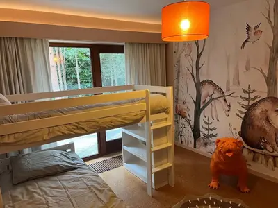 a bedroom with a bunk bed and a monkey wallpaper at Ardilla - holiday house in an oasis of green in Heusden - Zolder