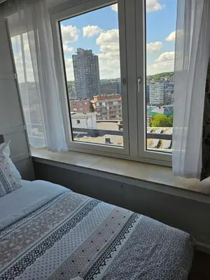 a bedroom with a window with a view of a city at Phocas in Liège