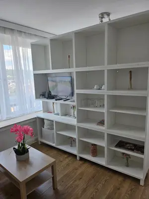a living room with white shelves and a table at Phocas in Liège