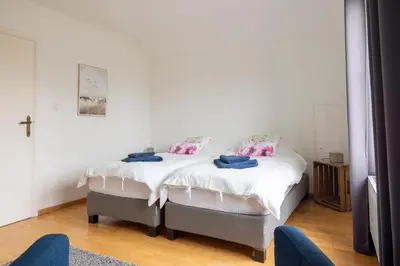 a bedroom with a white bed with two pillows at Villa Aluma in Sint-Truiden