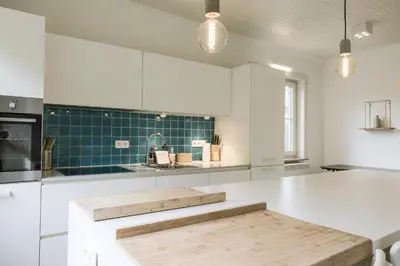 a kitchen with white cabinets and a white counter top at Villa Aluma in Sint-Truiden