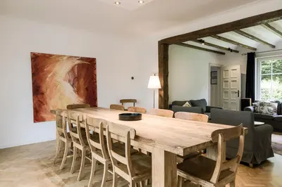 a living room with a wooden table and chairs at Villa Aluma in Sint-Truiden