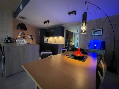 a room with a wooden table and a kitchen at Appartement tout eco-confort proche du centre in Liège