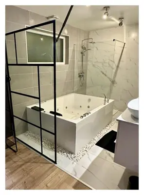a white bathroom with a tub and a sink at Loft de Waroux in Awans