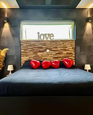 a bedroom with red pillows on a bed with a window at Loft de Waroux in Awans