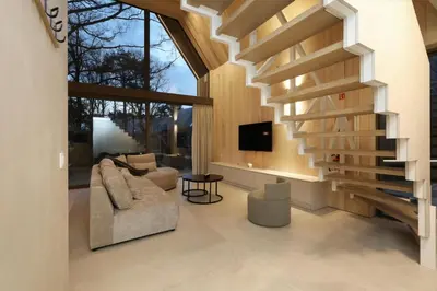 a living room with a staircase and a couch at Lodge - 4 personen - Woodz Lodges in Heusden - Zolder