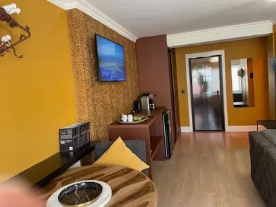 a living room with a couch and a tv on a wall at mi casa naranja in Lommel