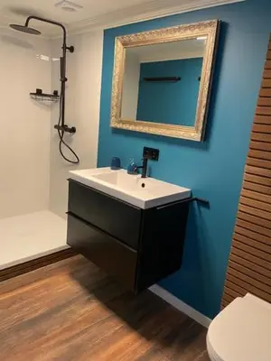 a bathroom with a sink and a mirror on a blue wall at mi casa naranja in Lommel