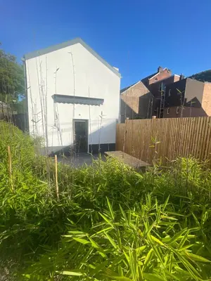a white building in front of a fence at Ô Gadot in Chaudfontaine