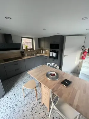 a kitchen with a wooden table and two chairs at Ô Gadot in Chaudfontaine
