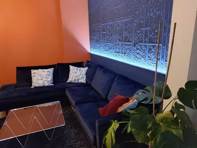 a living room with a blue couch and a window at LifeinLiege in Liège