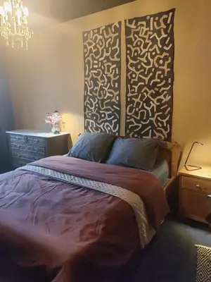 a bedroom with a bed and a chandelier at LifeinLiege in Liège