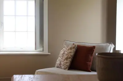 a pillow sitting on a couch next to a window at Vakantiewoning Molenveld in Dilsen-Stokkem