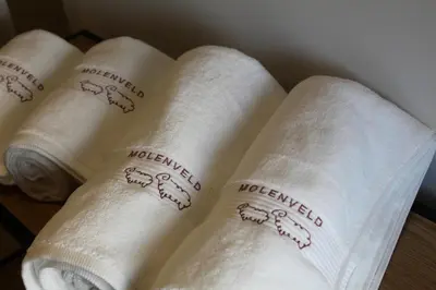 a group of white towels with the word welcomed at Vakantiewoning Molenveld in Dilsen-Stokkem