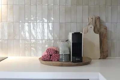 a kitchen counter with a coffee maker and roses on a tray at Vakantiewoning Molenveld in Dilsen-Stokkem