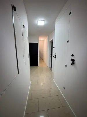 a hallway with white doors and a tile floor at Appartement Hoang in Ans