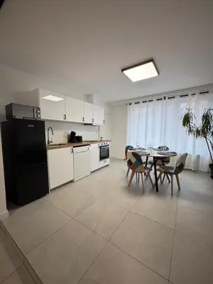 a kitchen with a table and a black refrigerator at Appartement Hoang in Ans